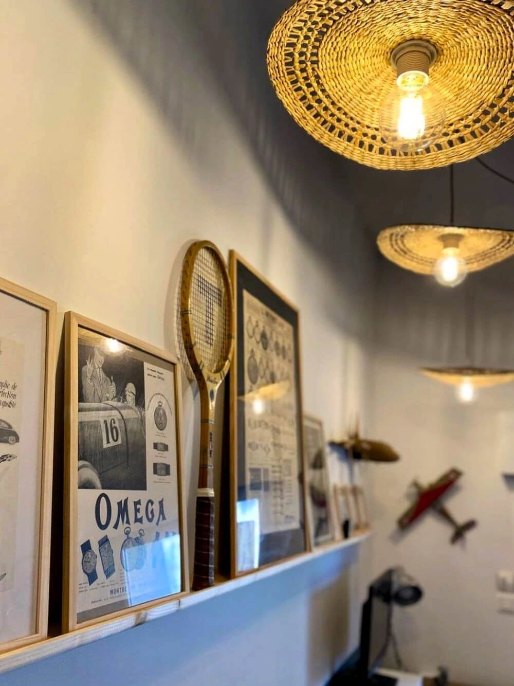 Une étagère avec une accumulation d'objets déco chinés et des raquettes pour une ambiance vintage