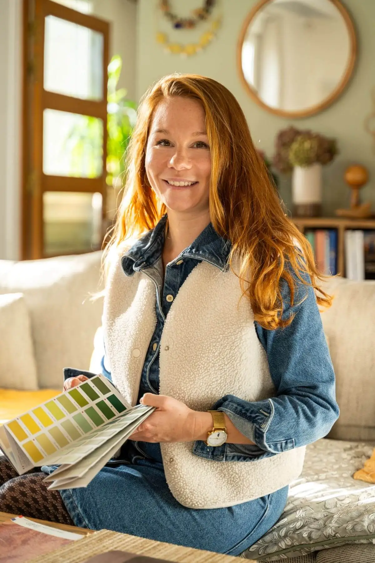 Camille Bisson, décoratrice d’intérieur, tenant un nuancier dans son salon