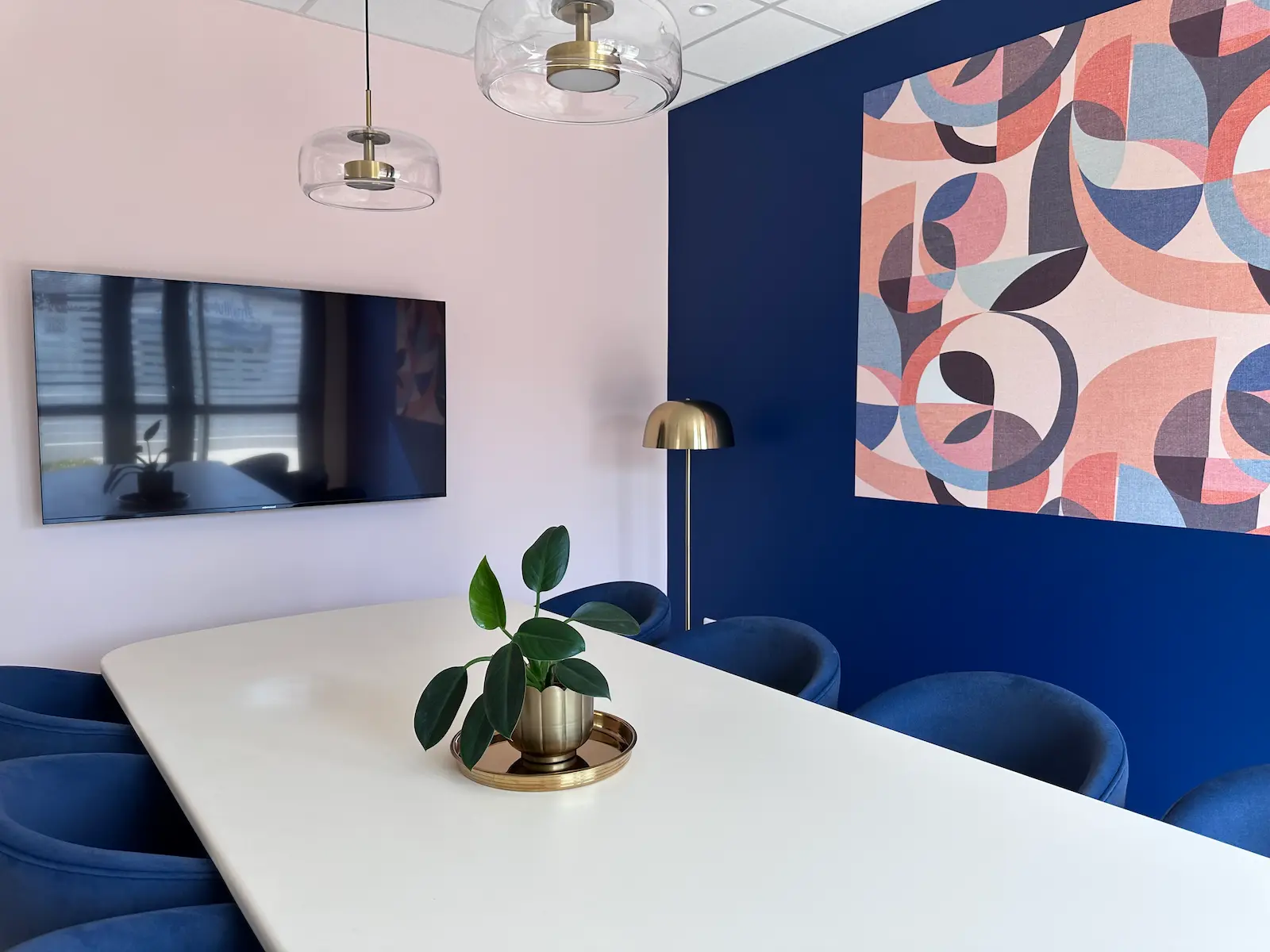 Papier peint à motifs dans les tons roses dans une salle de signature d’étude notariale pour créer une ambiance rassurante et accueillante